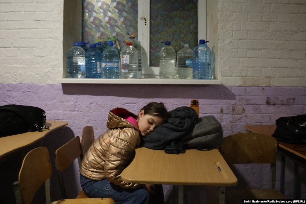 Дитина спить за столом в укритті