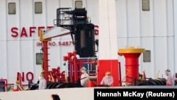 MV Hondius кемесинин жанындагы танкердин үстүндө турган медициналык кызматкерлер. Испания. 11-май, 2026-жыл.