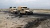 An Afghan military convoy drives past the site of a car bombing where U.S soldiers were killed near Bagram air base on April 9.