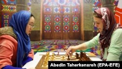 Chinese player Tan Zhongyi (L) faces Anna Muzychuk (R) of Ukraine in the first game of their Women's World Chess Championship final in Tehran, February 28, 2017