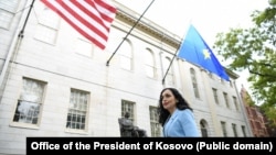 Presidentja e Kosovës, Vjosa Osmani, e fotografuar pranë flamurit amerikan dhe atij të Kosovës në SHBA.