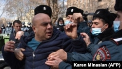 Armenian police detain an opposition protester at a rally to demand the resignation of prime minister in Yerevan on February 23.