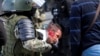 Riot police violently detain a protester during an opposition rally in Minsk against the election results.