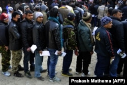 Nepalese migrant workers in Kathmandu queue to receive documents in order to leave Nepal.