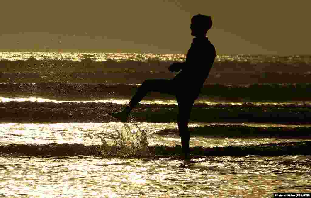 A man paddles as the sun sets at the beach in Karachi, Pakistan. (epa-EFE/Shahzaib Akber)