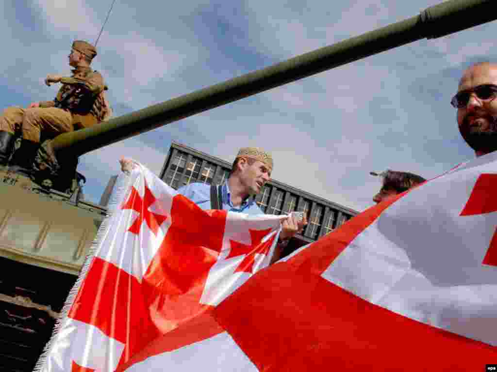 Чехія, 21 серпня 2008 р. - epa01460589 Georgian supporters protest against the Russian army in Georgia near a man in Soviet uniform sitting on a historical tank near Prague's national museum during an exhibition for the 40. commemoration of the Prague Spring in Prague, Czech Republic on 21 August 2008. The Czech Republic commemorates the 40th anniversary of the Soviet-led invasion into then Czechoslovakia. EPA/FILIP SINGER