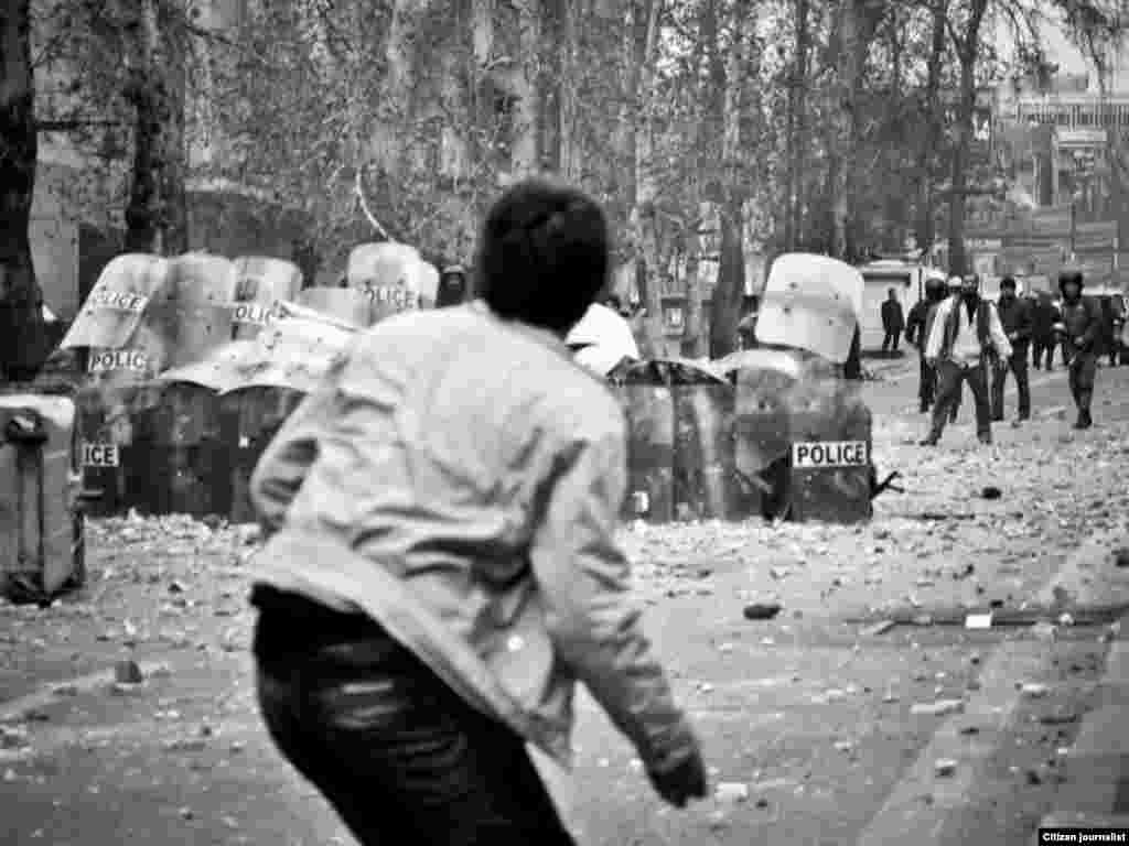 Iran -- Iranian opposition supporters throw stones towards riot policemen during clashes in Tehran on December 27, 2009.
