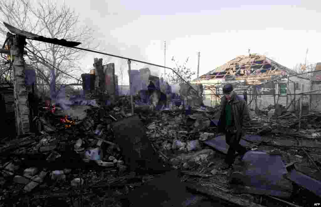 Місцевий житель проходить повз руїни свого будинку, знищенного внаслідок попадання снаряду зі складу