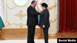 Täjigistanyň prezidenti Emomali Rahmon gyzy Ozoda Rahmona "At gazanan işgär" nyşanyny gowşurýar
