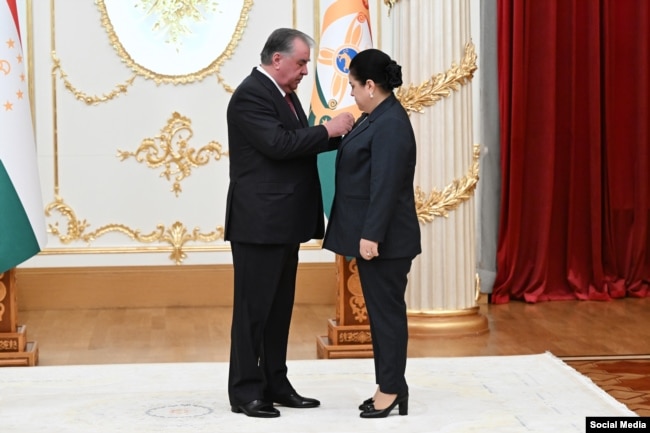 Президент Таджикистана Эмомали Рахмон вручает награду своей дочери Озоде, руководителю его администрации. Душанбе, 25 августа 2025 года