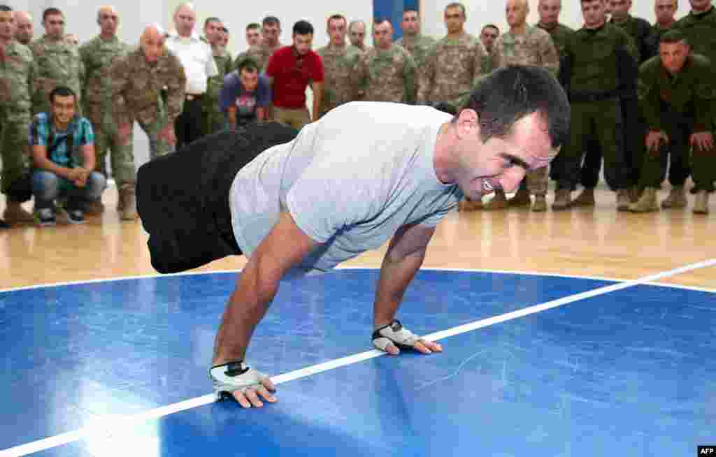 Corporal Temur Dadiani, 22, a double amputee military serviceman from Georgia sets the planche push-ups world record in one minute in Tbilisi on August 3. (AFP)