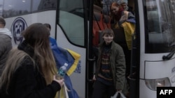 Ukrainian citizens, imprisoned in Belarus, exit a bus upon arrival in Ukraine's Chernihiv region following their release on November 22.