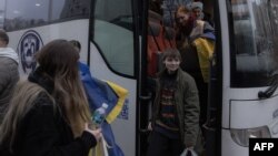 Ukrajinski državljani, zatvoreni u Bjelorusiji, izlaze iz autobusa po dolasku u Černihivsku oblast u Ukrajini nakon što su pušteni na slobodu 22. novembra.