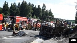Pamje e autobusit të shkatërruar nga ndeshja dhe zjarri, ndërsa shihen edhe ekipet e shumta të zjarrikësve gjermanë