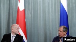 U.K. Foreign Secretary William Hague (left) has told Russian Foreign Minister Sergei Lavrov that all defense shipments to Syria must stop.