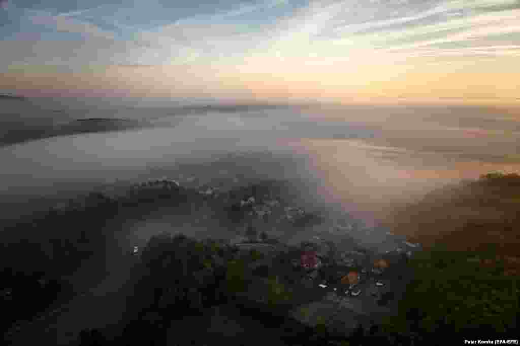 A picture taken with a drone shows morning fog hovering above the landscape during sunrise in Cered, in northern Hungary.