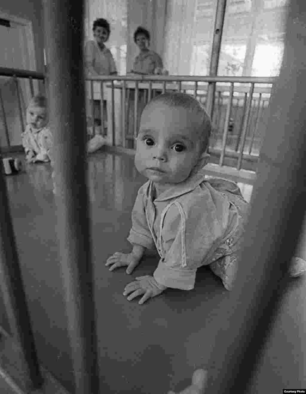 St. Petersburg-based photographer Aleksandr Belenky has spent years documenting the lives of children inside Russian orphanages. Here, a baby boy plays inside a crib in an orphanage in central St. Petersburg in 1991.