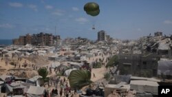 Палестинците купуваат хуманитарна помош доставена со падобран, Газа, 8 август 2025 година