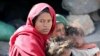 A woman looks as she sits with her children at a camp for internally displaced people on the outskirts of Sanaa, Yemen March 1, 2021.