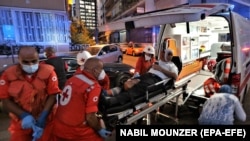 LEBANON -- Medics shift an injured person from Najjar Hospital to another hospital in Al-Hamra area in Beirut after Port explosion, in Beirut, August 4, 2020. 