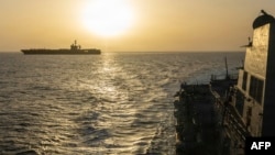 The USS Abraham Lincoln (left) conducts blockade operations in the Arabian Sea on April 16.