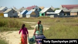 Members of the Roma community walk back home in the village of Pidvynogradiv near the Ukrainian city of Vynogradiv 