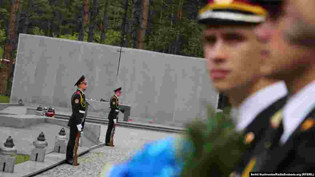 Почетный караул охраняет польский мемориал и стену с сотнями высеченных польских имен