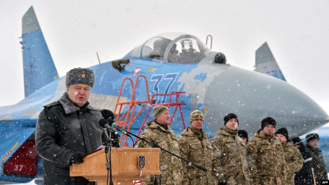Ukrainian servicemen listen on as Ukrainian President Petro Poroshenko gives a speech as he announces the handover of new military equipment to the Ukrainian forces in early January.