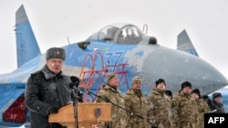 Ukrainian servicemen listen on as Ukrainian President Petro Poroshenko gives a speech as he announces the handover of new military equipment to the Ukrainian forces in early January.