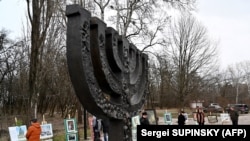 People gather near the monument at Babi Yar (Babyn Yar) in Kyiv for a memorial ceremony marking the International Holocaust Victims Remembrance Day on January 27.