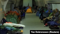 Люди ховаються всередині станції метро під час російського удару в Києві, 24 січня 2026 року