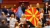 A kormányzó SDSM párt észak-macedón parlamenti képviselői európai uniós és észak-macedón zászlókkal a Bulgáriával fennálló viták rendezését és az uniós tagság felé vezető út megnyitását célzó, francia terv parlamenti vitája idején, 2022. július 16-án.