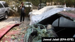 A damaged car in the aftermath of a rocket attack in downtown Kabul on August 18