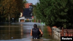 Inundații în Polonia. O persoană se deplasează prin apă, într-o zonă inundată de râul Nysa Klodzka, în orașul Lewin Brzeski. 17 septembrie 2024.