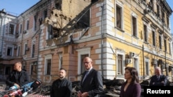 Ukrajinski predsjednik Zelenski, njemački kancelar Merz i njemačka ministrica energetike Reiche ispred zgrade Ukrajinske nacionalne akademije nauka u Kijevu, oštećene u ruskim napadima, 4. oktobra 2026.