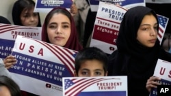 Afghan refugees in the Pakistani capital, Islamabad, hold placards during a meeting earlier this year to discuss their situation after US President Donald Trump paused refugee programs. 