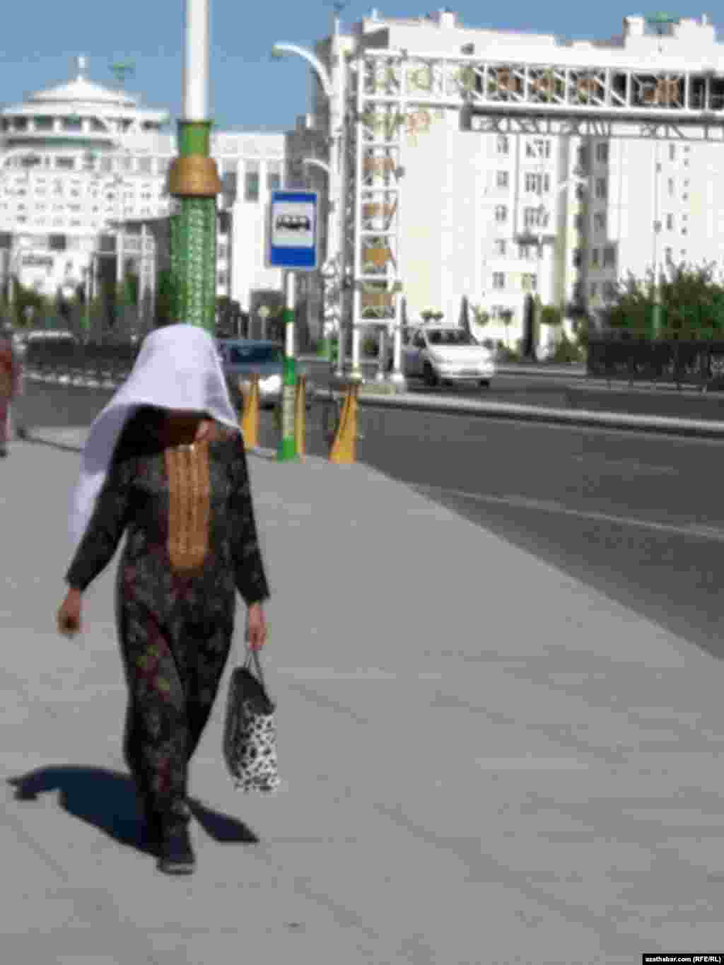 Aşgabat. Günden goranmak üçin ýaglygyny ýüzüne ýapyp gelýän aýal. Iýun, 2020.&nbsp;