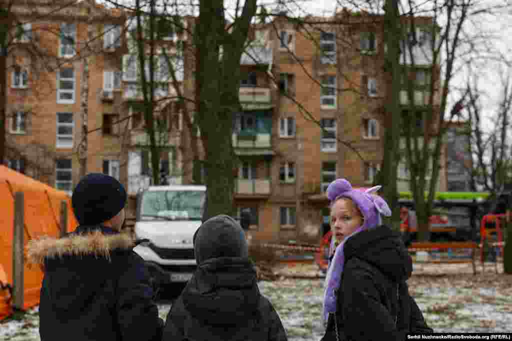Діти дивляться на пошкоджений російським обстрілом будинок у Києві