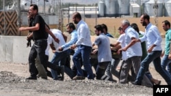 Turkish police officers and rescue personnel carry the body of an injured man at the site of a car-bomb explosion in Diyardakir on August 15.
