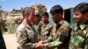 На этой фотографии, сделанной 6 июня 2019 года, командующий силами США и НАТО в Афганистане генерал Скотт Миллер (слева) пожимает руку солдатам Афганской национальной армии (АНА) во время посещения блокпоста в районе Нерх провинции Вардак на западе Кабула