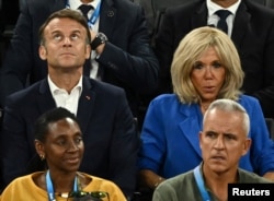 Emmanuel Macron la finala baschetului feminin, pe 11 august, privind în sus, de unde ar trebui să-i vină de-acum inspirația pentru formarea noului guvern.