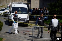 Turkish police officer gather outside the Israeli Consulate in Istanbul on April 7 following a shootout between gunmen and police.