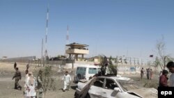 Afghan security officials inspect the site of a bomb attack in Helmand in June.