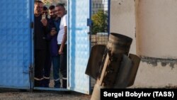 NAGORNO-KARABAKH -- Lccal people look the remains of a rocket shell on a street after recent shelling in Stepanakert, October 15, 2020