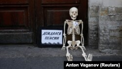 "Waited for pension": A model skeleton lies on the ground during a protest against the government's plan to raise the pension age in St. Petersburg on July 19.