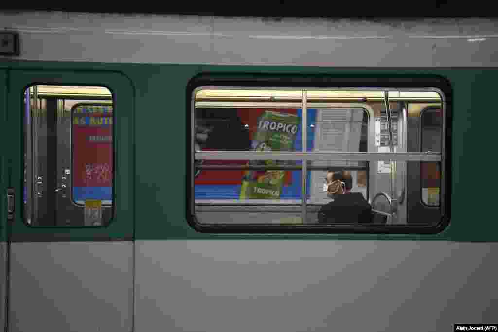 France - A commuter wears a protective facemask as he sits in the carriage of a metro in Paris, 23March2020