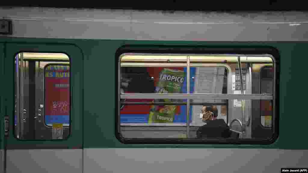 France - A commuter wears a protective facemask as he sits in the carriage of a metro in Paris, 23March2020