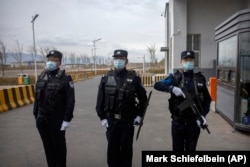 Chinese security personnel stand outside an alleged detention facility for Uyghurs and other Muslim minorities in China's western Xinjiang Province.