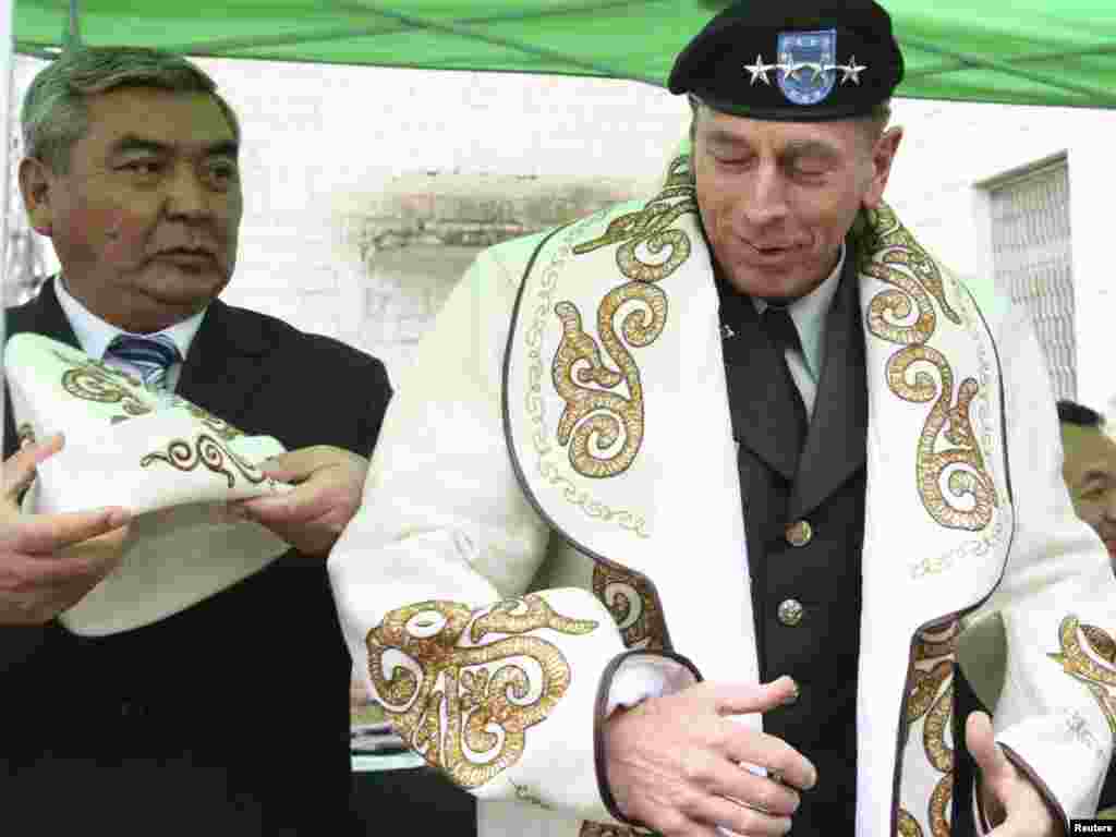 General David Petraeus, the head of U.S. Central Command, tries on Kyrgyz national dress in Shopokove, near Bishkek. - Petraeus visited Kyrgyzstan on March 11 to discuss counterterror efforts and cooperation in fighting the insurgency in Afghanistan. Photo by Vladimir Pirogov for Reuters