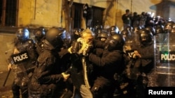 Police detain a demonstrator as they violently disperse crowds protesting against the government in Tbilisi early on November 29.